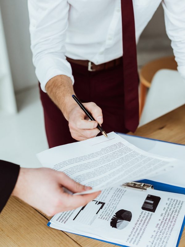 cropped view of businesspeople working with documents and signin cropped view of businesspeople working with documents and signing contract