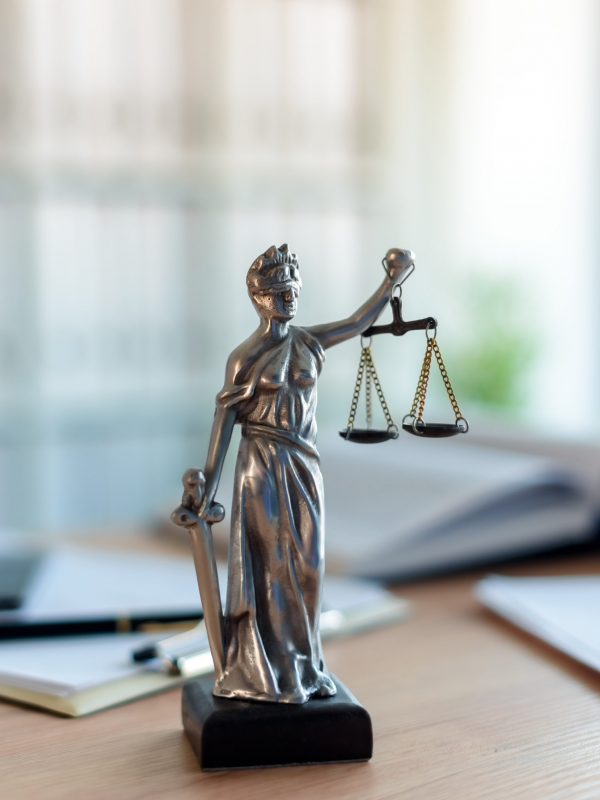 Lady Justice statue in law firm office Lady Justice statue in law firm attorney office, blindfolded Justitia with balance scales and sword is personification of moral force in judicial system